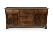 An antique English oak kitchen dresser base with cockbeaded drawers and brass swing handles, 18th/19th century, 86cm high, 170cm wide, 52cm deep.