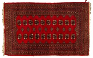 A hand-knotted North Indian rug on crimson ground with black highlights, 197 x 126cm