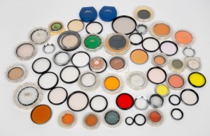 VARIOUS MANUFACTURERS: An accumulation of more than fifty lens filters of varying size and colour, most in plastic cases, from brands such as Accura, Hoya, Photape, and Walz. (50+ items)