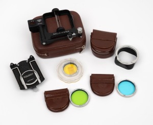 ROLLEI: An accumulation of six camera attachments, comprising one tripod head, one Rolleimeter in leather case, one RII lens hood in leather pouch, two RII lens filters in leather pouches, and one RI lens filter. (6 items)