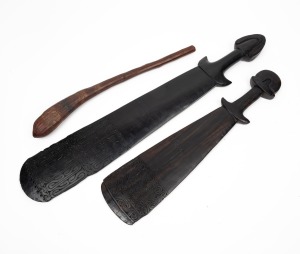 Two Papua New Guinea sword clubs with carved decoration; together with a throwing club, (3 items), the largest 67cm long