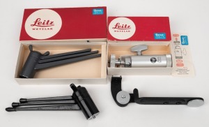 LEITZ: Group of four camera attachments comprising one Leica 14100 TOOUG tripod in grey with maker's box, one Leica 14100 TOOUG tripod in black, one Leica 14121 tripod head with maker's box, and one CTOOM flash bracket. (4 items)