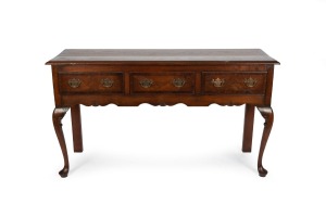 An English oak and mahogany three drawer dresser base with cabriole legs and brass swing handles, made in the Georgian style, early 20th century, 85cm high, 152cm wide, 48cm deep.