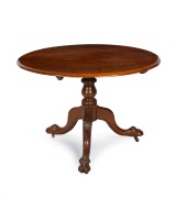 An antique Australian cedar circular tilt-top supper table with carved lion paw feet, 19th century, 75cm high, 103cm diameter