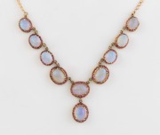 An Italian 9ct yellow gold choker necklace, set with nine solid polished opals each surrounded with rubies, 20th century, ​​​​​​​28cm long, 13.4 grams total.
