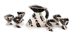 PATSY HELY&nbsp;seven piece ceramic drink set comprising of a jug and six vessels, triangular form with black and white finish, signed "P. H.", the jug 17cm high, 26cm wide