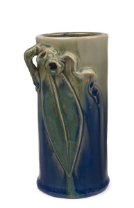 REMUED blue and green glazed pottery vase with grey and pink highlights, adorned with gumnuts, leaf and branch handle, incised "Remued, Hand Made, 145/SM", 16.5cm high.