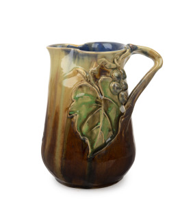 REMUED pottery jug with applied grape decoration, incised "Remued, Hand Made, 189M", ​​​​​​​20cm high.