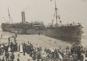 HMAT ASCANIUS, WW1 period black and white albumen photograph by Josiah Earl Barnes (Aust., 1858&ndash;1921) of an Australian troop ship departing Station Pier in Port Melbourne, mounted on card with ply surround, 38 x 53cm, 51 x 66cm overall.