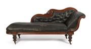 An antique Australian cedar chaise longue with scroll back and end rests, decorated with applied rosette rondels, on faceted baluster legs and original brass castors. Retaining antique leatherette diamond button upholstery, original colour, finish and pat