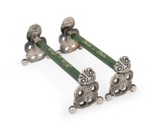 A pair of antique English sterling silver and New Zealand greenstone knife rests with Tiki ends, made in Birmingham, circa 1913, 3cm high, 7cm wide.