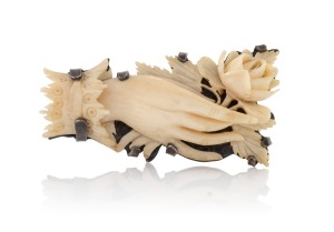 An antique Australian silver mounted carved ivory brooch in the form of an elegant hand holding a rose, 19th century, stamped "STG. Sil.", 4.7cm wide