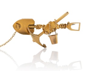 An antique 18ct gold miner's brooch with cross pick and shovel and gold nugget specimen entwined in rope with a suspended bucket, 5.5cm wide, 7.5 grams.