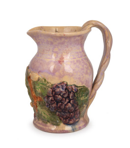 UNA DEERBON pink glazed pottery jug with applied grapes and leaves, incised "Deerbon", 13.5cm high