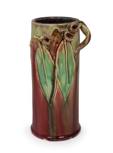 REMUED cylindrical pottery vase glazed in pink and green with blue interior and decorated with applied gumnuts, leaves and branch, incised "Remued Hand Made, 145/9M", 23.5cm high