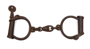 HIATT "Backstrap Hinge" convict handcuffs with key, circa 1840, 23cm wide.