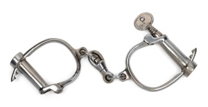 REUBEN CRADDOCK & SONS vintage nickel finished adjustable handcuffs with skew-key, circa 1930. 25cm wide.