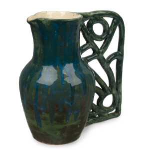 UNA DEERBON rare green and blue glazed pottery jug with unusual hand-built stylised handle, incised "Deerbon, 167", 24cm high, 23cm wide.
