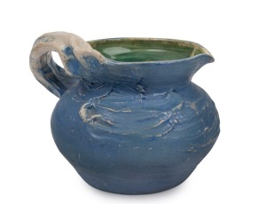 PHILIPPA JAMES blue and green glazed pottery jug with windswept decoration, incised "Philippa James", 15.5cm high, 19cm wide.