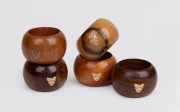 A set of five Australian timber napkin rings, each decorated with a 9ct gold map of Tasmania, early 20th century.