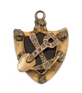An antique shield shaped gold and diamond cross pick and shovel miner's pendant, 19th century, ​​​​​​​3cm high, 3.7 grams total including stones.