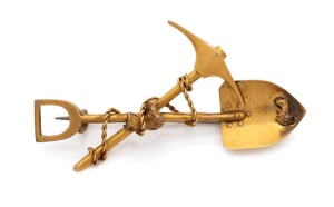 An antique yellow gold miner's brooch with crossed pick and shovel, nugget specimens and entwined rope, 19th century, 5.5cm wide, 5.3 grams.