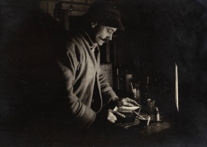 TERRA NOVA EXPEDITION: Original silver gelatin photograph, 16.5 x 11.5cm, numbered '312' in pencil in Herbert Ponting's hand, known to have been titled by Ponting "Herbert Ponting at work in the Darkroom at Winterquarters Hut. July 22nd 1911".