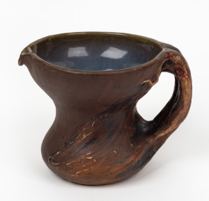 PHILIPPA JAMES brown glazed pottery jug with windswept tree handle, incised "Philippa James", 13.5cm high, 18cm wide.