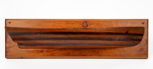 An antique Australian cedar and pine half hull boat builder's model on later back board, 19th/20th century, 16 x 57cm.