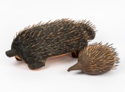 Two echidna sculptures, carved wood, paint and quills, the larger 48cm long