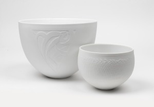 LES BLAKEBROUGH Australian porcelain bowl with gum leaf decoration; together with a white porcelain bowl titled "In The Long Grass With Claudia Rose", (2 items), both stamped with artists monogram "L.B.", 18cm and 11.5cm high