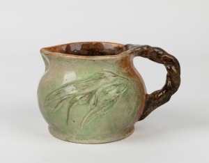 WILLIAM ANDERSON green and brown glazed pottery jug with applied gumnuts, blossoms, leaves and branch handle, incised "W. Anderson, Lorne, Clay", 11cm high, 17cm wide.