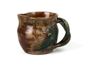 STAN and GEOFF GILBERT brown and green glazed pottery jug with applied gumnut, leaf and entwined branch handle, incised "S. & G. Gilbert, Vic. Aust.", ​​​​​​​8.5cm high.