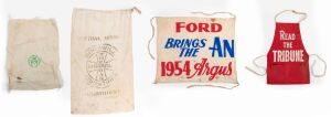 "READ THE TRIBUNE" red cotton apron; together with a cotton banner "FORD BRINGS THE AN 1954 ARGUS", a "Central Mission Melbourne, Goodwill Industries, The Goodwill Bag" flour bag and a Reserve Bank of Australian cotton cash bag, 20th century, (4 items), the banner 62 x 70cm