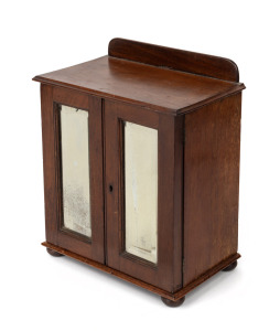 An antique walnut apprentice cabinet with two mirrored doors revealing four drawers, 19th/20th century, 32cm high, 26cm wide, 16cm deep.