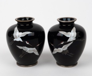 A pair of Japanese cloisonne vases with flying crane decoration on black ground with silver rims, 20th century, 9cm high.