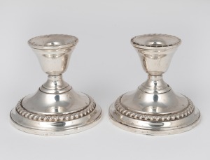 A pair of sterling silver candle holders with weighted bases, 20th century, 8.5cm high.