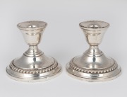A pair of sterling silver candle holders with weighted bases, 20th century, 8.5cm high.