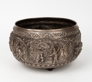 A vintage Burmese silver plate on copper bowl with ornate repousse decoration, 20th century, 15cm high, 24cm wide.