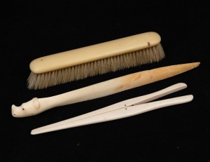 An antique carved ivory glove stretcher, carved ivory letter opener with rhinoceros handle and an ivorine brush, 19th and 20th century, (3 items), the largest 25cm long.