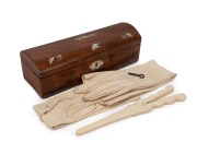 An antique English William IV dome top rosewood glove box with original key, kid gloves and fine quality ivory glove stretcher, 19th century, the box 25cm wide.