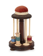 An antique rosewood, bone and ivory thread holder with pin cushion top, 19th century, 14cm high.