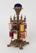 An antique American cast metal spool holder with pin cushion top and assorted threads, 19th/20th century, 25cm high. - 2