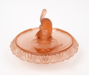 A peach depression glass float bowl with pelican centrepiece, circa 1930, 22cm high, 31cm wide.