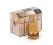An antique English 18ct gold thimble with Greek key decoration, housed in an antique pearl shell case, 19th century, 5 grams.