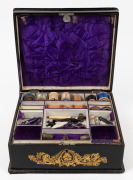 An antique English papier-m&acirc;ch&eacute; sewing workbox fitted with lift-out tray and compartments adorned with original purple velvet and silk, also includes a selection of threads, thimbles, shuttles and sewing accessories, 19th century, 14cm high, 28cm wide, 25