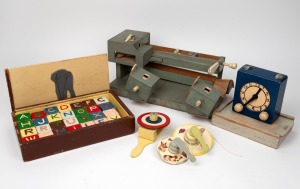 Folk art toy clock, spinning tops, alphabet blocks, unusual pin ball game and whirling toy, mid 20th century, (6 items), the pin ball game 45cm wide.