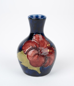 MOORCROFT "Hibiscus" pattern English pottery miniature vase on blue ground, impressed "Moorcroft, Made In England", 9cm high.