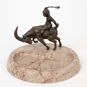 An antique Continental cast bronze and rouge marble dish featuring a putti riding a ram, early 20th century, 15cm high, 20cm wide.