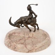 An antique Continental cast bronze and rouge marble dish featuring a putti riding a ram, early 20th century, 15cm high, 20cm wide.